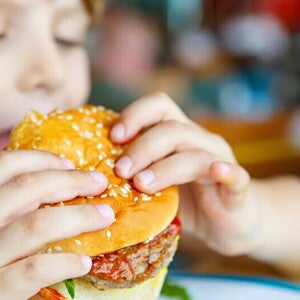 a boy eating burger