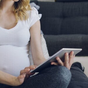 pregnant woman making heart shape with hand