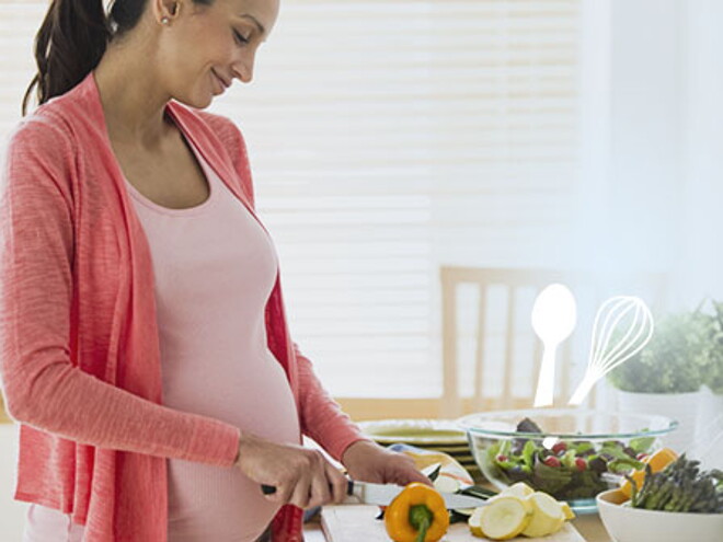 Pregnant woman cutting vegetable Pregnant woman cutting vegetable