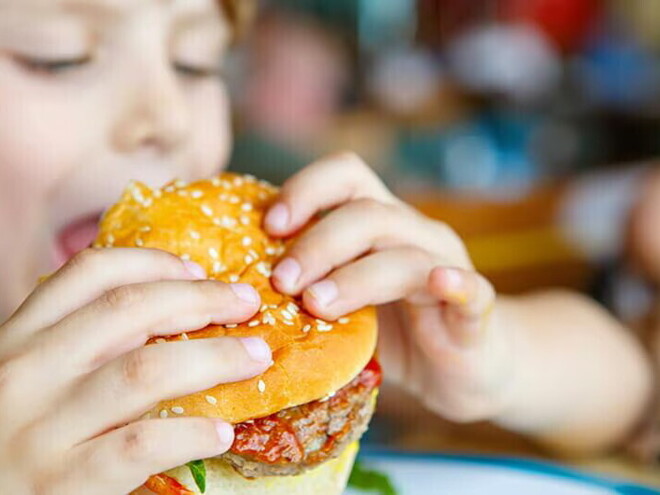 a boy eating burger