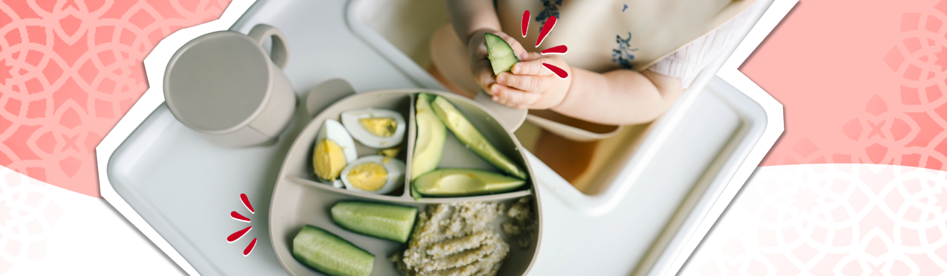 Top-down photo: white tray with green sushi rolls, tea bowl with flower, chopsticks on pink pattern
